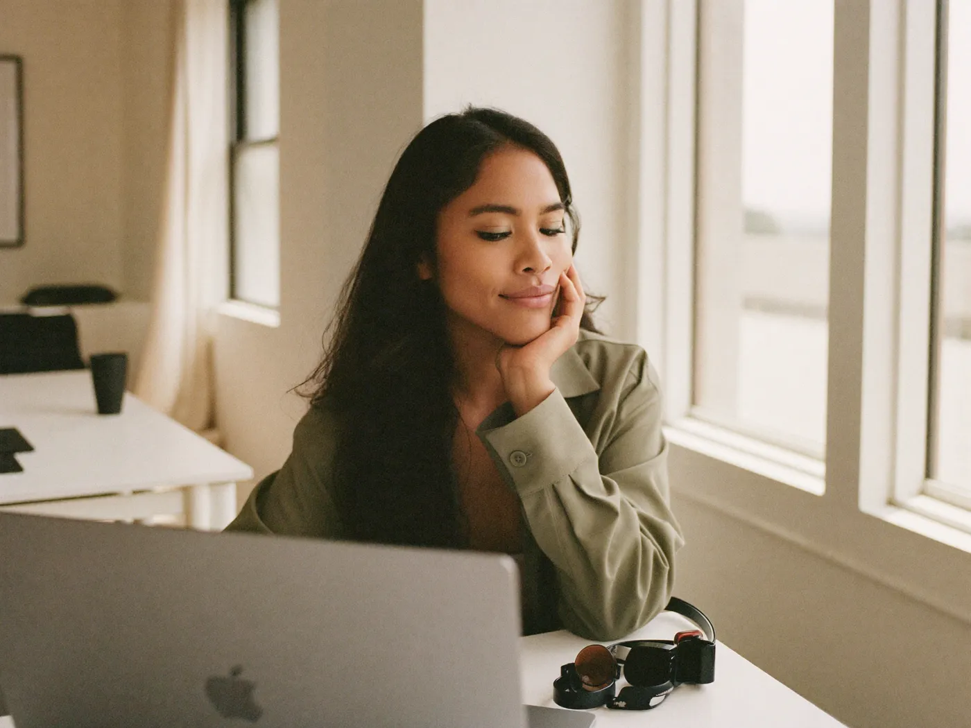 A window and door company owner reviewing marketing results on a laptop in a bright office